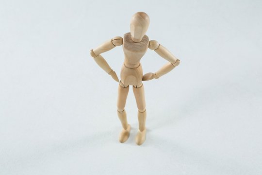 Wooden figurine standing with hands on his waist