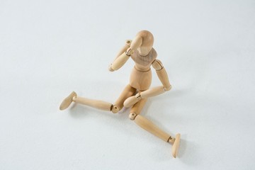 Tired wooden figurine with hand on forehead