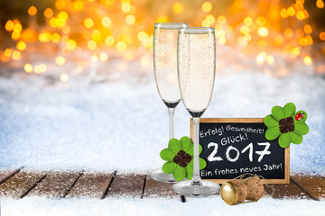 2017 Silvester bokeh Hintergund mit Sektfgläsern Sektkorken Tafel Grüßen und Wünschen im Schnee...