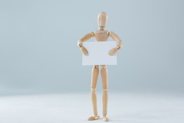 Wooden figurine holding blank placard