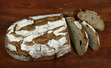 Loaf of sliced whole grain bread on wood bread board