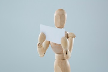 Wooden figurine holding blank placard