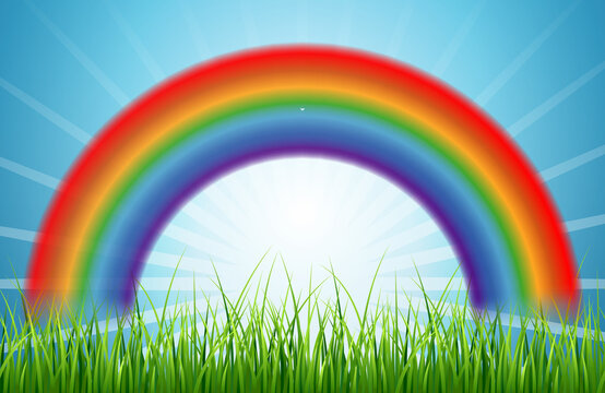 Bright rainbow blue sky with rising sun and green grass