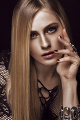 Beautiful blond woman with healthy skin and hair, red manicure, posing in studio. Beauty face