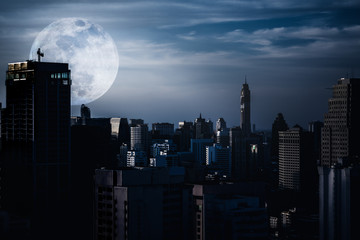 Silhouettes of skyscrapers different  construction with backgroud of a full moon