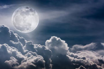 Nighttime sky with clouds and bright full moon with shiny.  