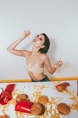 Sexy alluring woman sitting at the table with french fries