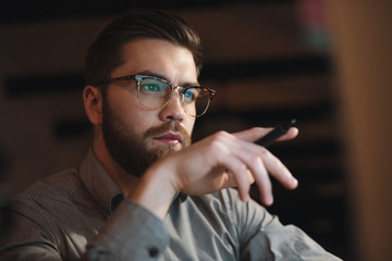 Concentrated web designer looking at computer. Holding pen.