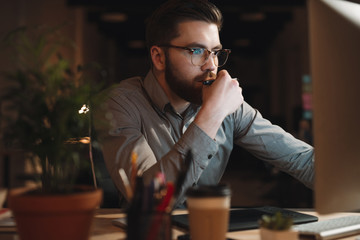 Obraz premium Designer working late at night and looking to computer