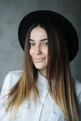 portrait of a girl brunette in black hat and white shirt. She is smiling cute