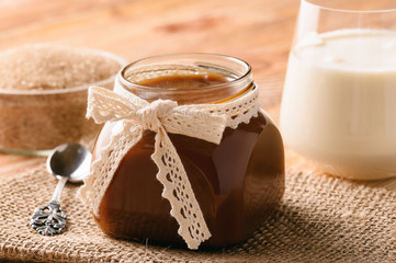 Caramel sauce on brown wooden background. 
