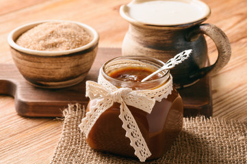 Caramel sauce on brown wooden background. 