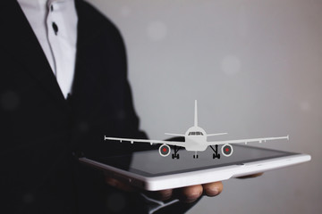 man hand hold tablet and airplane