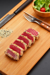 Grilled tuna fillet on a wooden board.