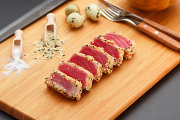 Grilled tuna fillet on a wooden board.