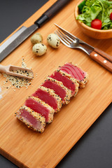 Grilled tuna fillet on a wooden board.