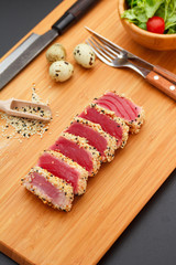 Grilled tuna fillet on a wooden board.