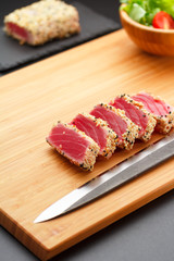 Grilled tuna fillet on a wooden board.