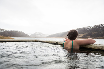 Beautiful girl in a hot pot in Iceland during winter