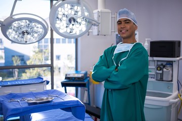 Portrait of surgeon standing with arms crossed in operation room