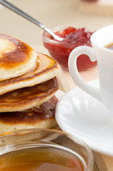 Hot pancakes with honey and white cup of tea