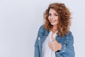 Smiling Woman in jean jacket with thumb up