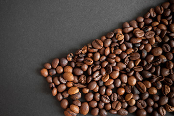roasted coffee beans over black paper background