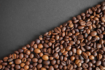 roasted coffee beans over black paper background