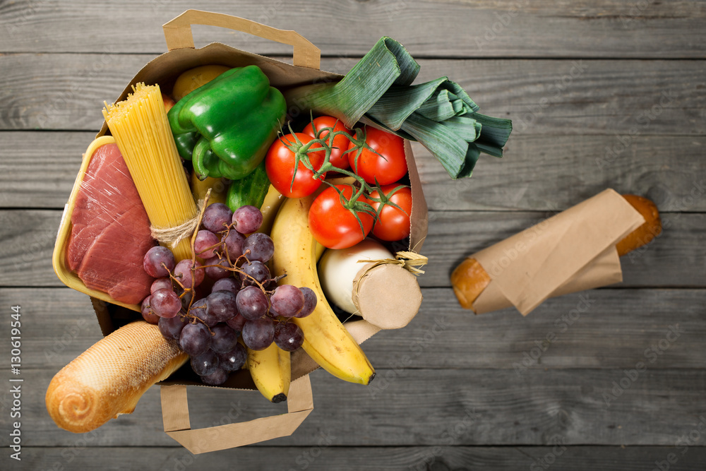 Canvas Prints Full paper bag of food products on wooden background