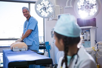 Obraz premium Doctor interacting with girl while examining a dummy