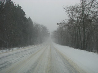 Obraz premium Side road in the forest during the winter season covered with snow and ice