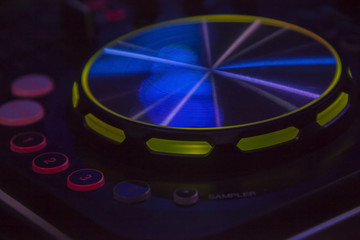 Close-up of DJ mixer console with backlighted buttons