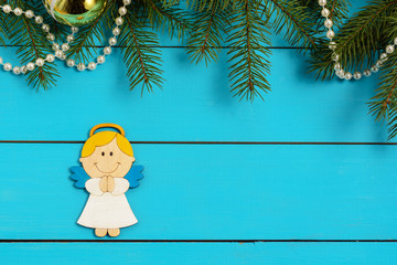 Christmas angel and fir twig on blue background