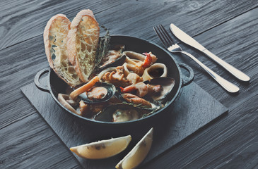 Seafood Stew in Saucepan on dark wood background