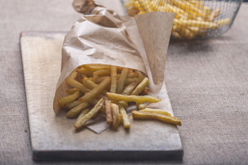 Fresh fried french fries with ketchup on wooden background