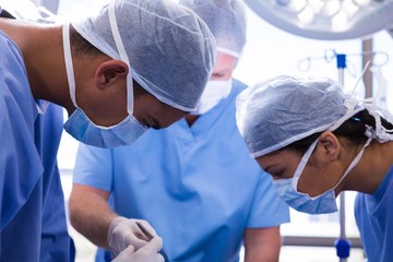 Group of surgeons performing operation in operation room