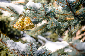 Christmas background with golden bells on the Christmas tree 