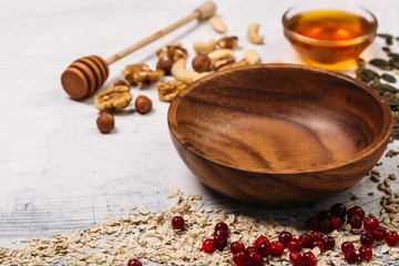 Cereal and various delicious ingredients around empty plate for breakfast on white background. Top view.