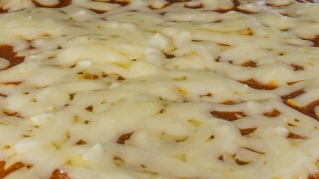 Melting pizza cheese macro close up time lapse.