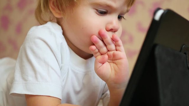 child looks cartoons on tablet pc closeup