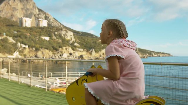 Little girl rides the spring rider in the children's park