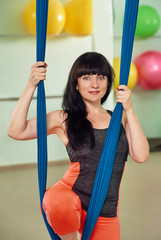 middle-aged woman with aerial yoga hammock