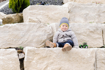 Kleinkind sitzt auf Granitblock