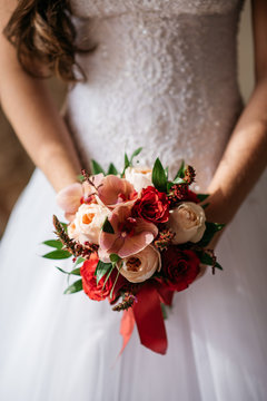 Cropped image of wedding bouquet in hands of the bride,  indoors