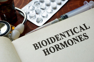 Book with words bioidentical hormones on a table. - obrazy, fototapety, plakaty