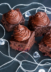 Christmas chocolate cake bites with cream and berries in dark festive decoration - healthy food idea for holiday dessert