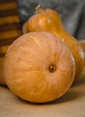 Two pumpkins on wooden table. against the backdrop of coasters