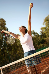 femme qui saute de joie sur un court de tennis