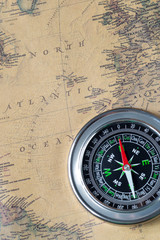 the Black compass on old vintage map, north atlantic ocean, macro background