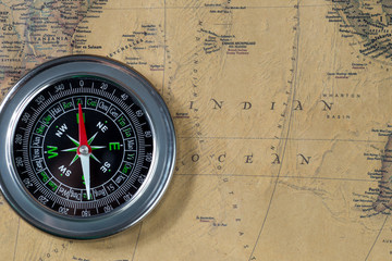 the Black compass on old vintage map, indian ocean, macro background